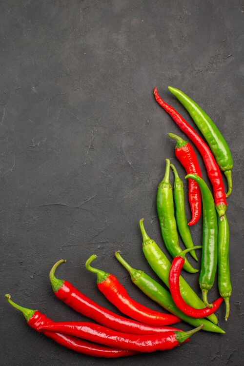 胡椒顶视图红色和绿色的辣椒在右侧的黑表与自由空间黑色辣椒烹饪