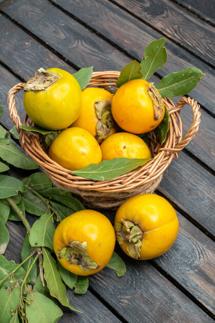 农产品在木制书桌上的篮子里可以看到新鲜的柿子里面新鲜前面