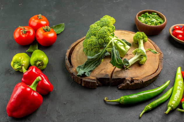 生菜前视图新鲜西兰花与西红柿和甜椒在黑暗的背景食物健康蔬菜