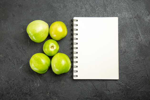 苹果顶视图绿色西红柿一个笔记本在黑暗的表面食物顶级碎樱桃