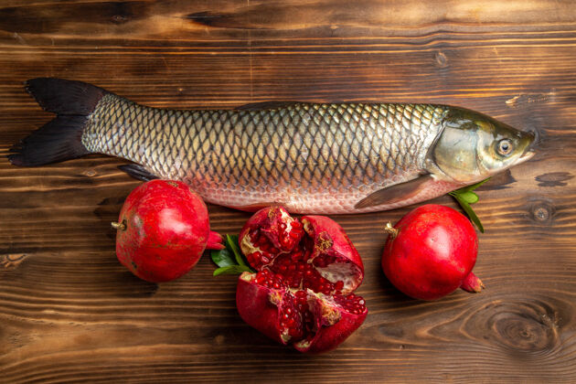 海鲜木桌上的石榴鲜鱼俯瞰图胡椒食物新鲜的鱼