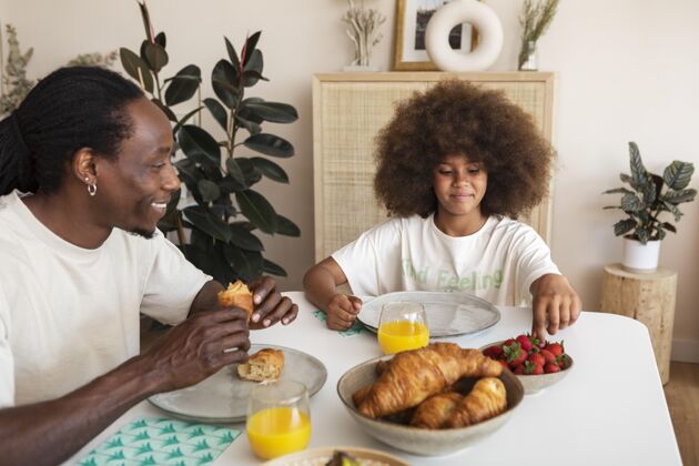 室内小女孩和她爸爸一起吃早餐女孩水平年轻人
