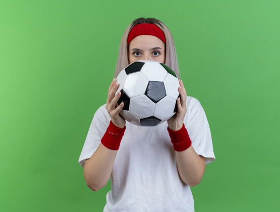 头带印象深刻的年轻白人运动女孩戴牙套头带背带球年轻
