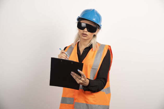 女人带着护目镜和剪贴板的年轻女建筑工人高质量的照片女孩制服人