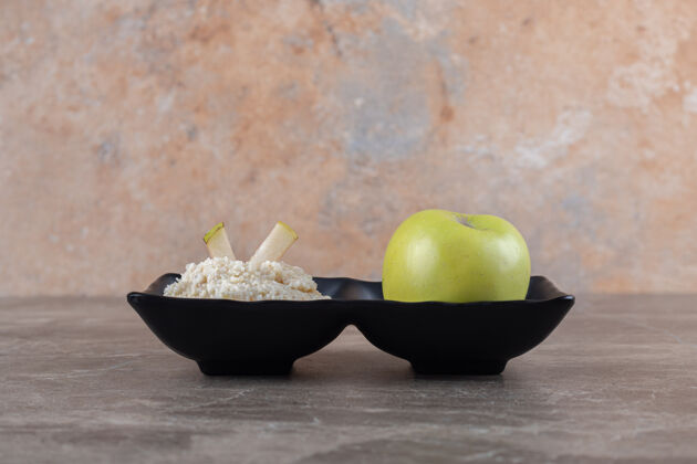 水果磨碎的年糕和苹果在碗里 在大理石表面感恩板子大米