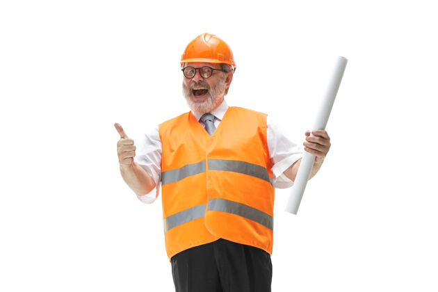 人穿着建筑背心和橙色头盔的快乐的建设者在工作室微笑帽子工地头盔