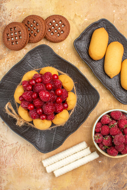 零食垂直视图的礼物蛋糕和饼干在棕色盘子水果混合色背景甜点水果覆盆子