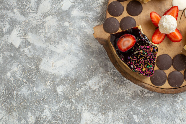 木头俯瞰美味的蛋糕片和巧克力饼干在白色表面玻璃黑色甜点