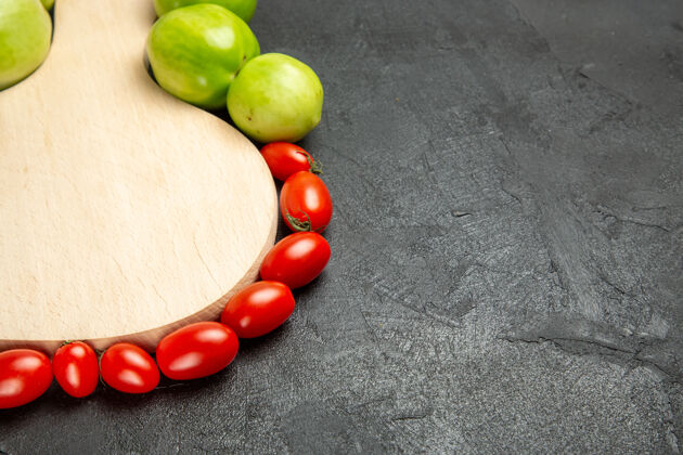板底部近距离观看绿色和红色的西红柿围绕在一个砧板上黑暗的背景排骨健康新鲜