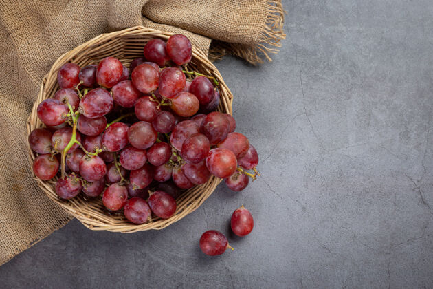 生动一串串新鲜成熟的红葡萄放在黑暗的表面上葡萄酒边界葡萄藤