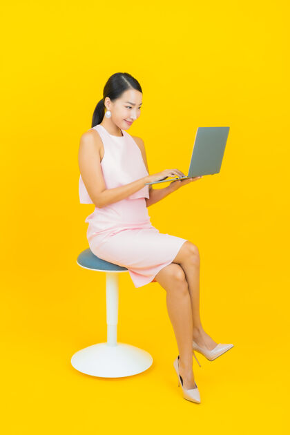 工作肖像美丽的亚洲年轻女子微笑着用黄色笔记本电脑企业家韩国人成年人