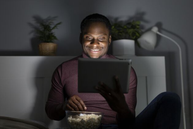 娱乐非裔美国人在室内看netflix订阅电视休闲