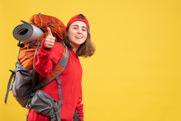 成人正面图穿着红色背包的年轻旅行家妇女伸出大拇指拇指女士年轻
