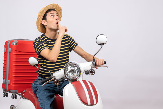 人一个戴着草帽的年轻人坐在轻便摩托车上做着安静的手势车辆前面景观