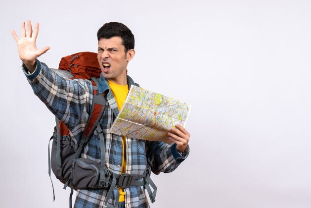 人正面图年轻的露营者背着背包拿着地图做停车标志前面成人男