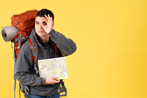 向上前视图旅行者男子背着背包拿着地图举着好的标志在眼前视图抱着微笑