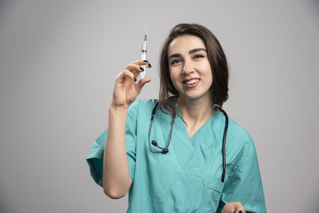 女性身着制服的快乐医生与注射器合影高质量照片听诊器健康妇女