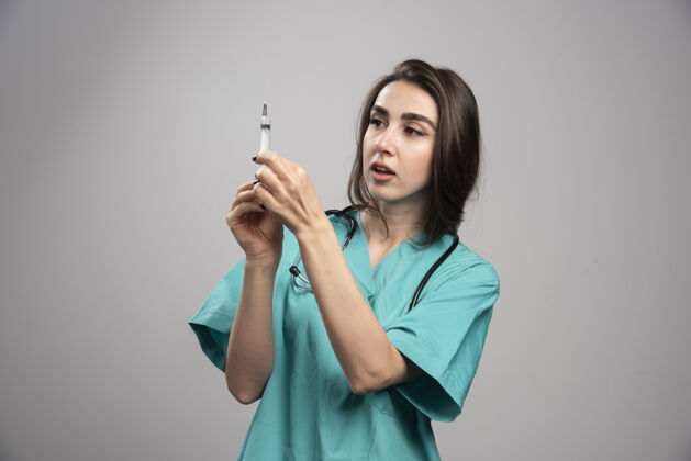 妇女身着制服的快乐医生与注射器合影高质量照片工作注射器医院