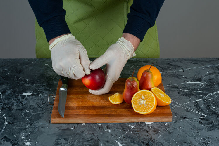 手男手切红苹果放在桌上的木板上混合男切片