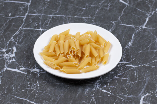 堆白盘子上的意大利面生的未煮熟的意大利面就可以煮了饮食餐厅营养