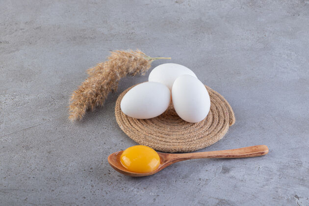 美味生鸡蛋放在石头表面上母鸡未煮熟食物