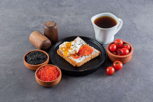 新鲜美味的烤面包配上新鲜的红樱桃番茄和一杯茶杯子马克杯樱桃