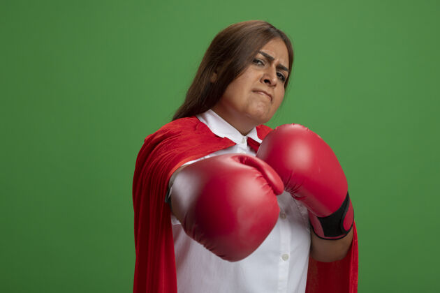 握自信的中年女超人戴着拳击手套 伸出一只孤立的手就绿了自信中年超级英雄