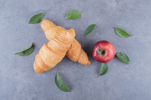美食灰底法式牛角面包和新鲜苹果的俯视图有机食谱糕点