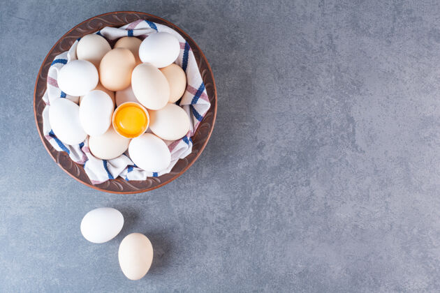 蛋壳放满有机鸡蛋的陶瓷碗放在石桌上烹饪家禽生的