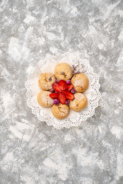 糖白色表面上有草莓的美味甜饼俯视图冬青水果灌木