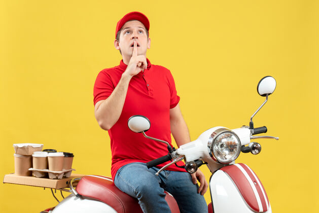 车辆身穿红色上衣 头戴帽子的年轻人在黄色背景下默哀致意的前视图背景摩托车轻便摩托车