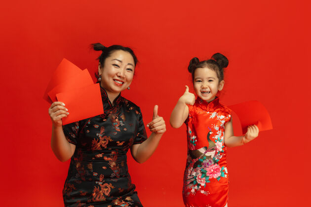 灯笼新年快乐隔离在红墙上的亚洲母女画像欢乐版权空间家庭