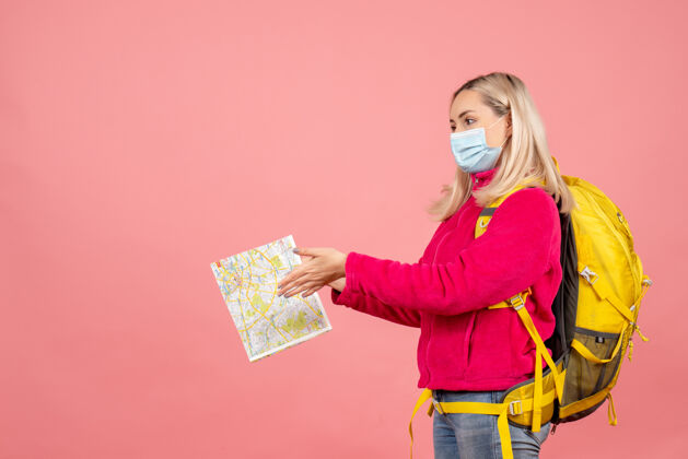女士前视图旅行妇女戴着黄色背包戴着面具拿着地图穿时尚前面