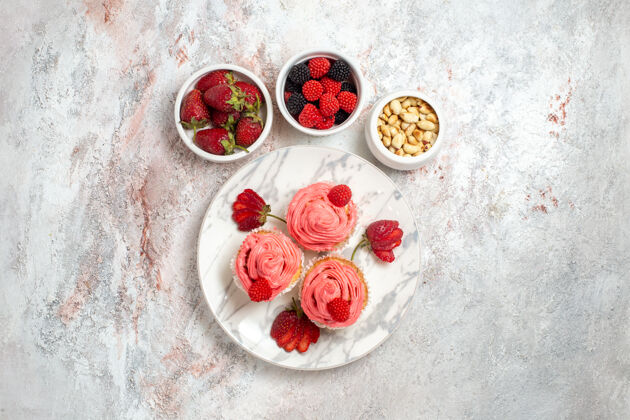 可食用水果白色表面上有坚果的粉色草莓蛋糕俯视图草莓茶食品