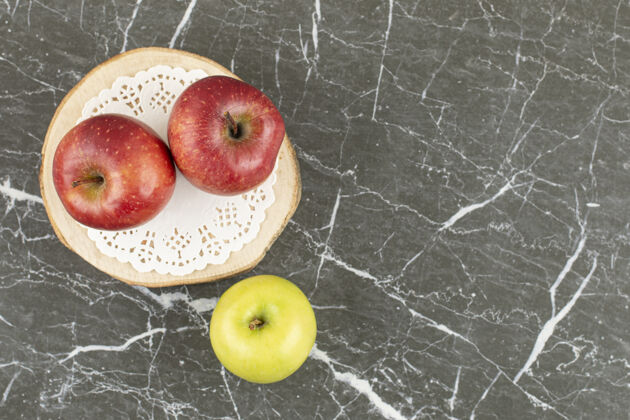 健康木板上两个红苹果和一个绿苹果的顶视图成熟素食切片