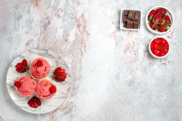 果酱白色表面有果酱和巧克力棒的粉色草莓蛋糕俯视图饼干材料质地