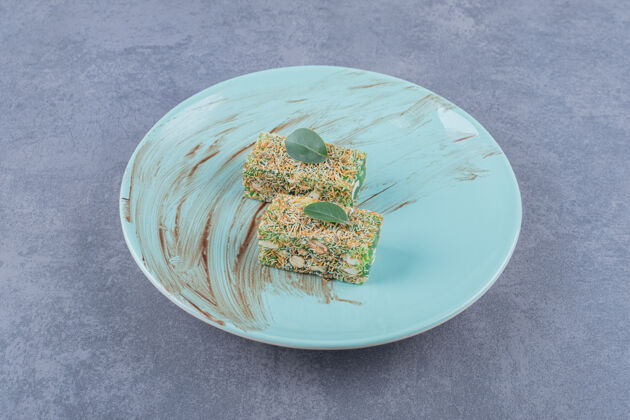膳食绿色盘子上放着榛子的土耳其拉哈特巧克力喜悦犹太榛子