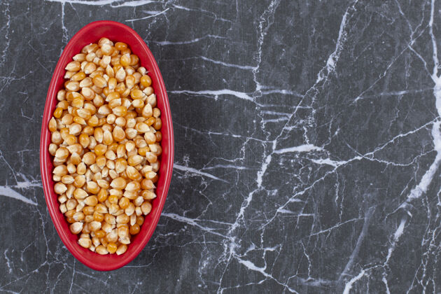 有机一堆玉米种子在红碗里膳食健康团体