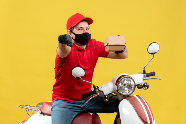 摩托车苏密林送货员身穿红色上衣 戴着帽子手套 戴着医用面罩 坐在滑板车上的俯视图 显示订单指向前方摩托车车辆坐