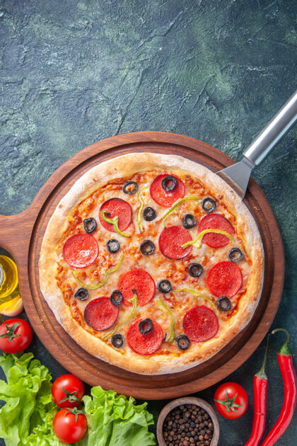 板美味的自制比萨饼在木板上油瓶西红柿胡椒绿色包在黑暗的表面底部食物营养品晚餐