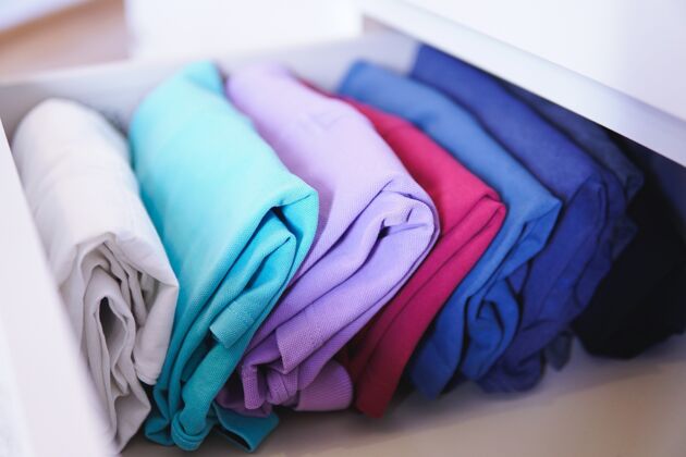 衬衫许多不同的折叠衣服完美地安排在一个壁橱-玛丽近藤近马方法的概念织物家务衣服