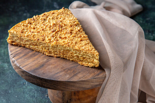 切片正面是美味的蜂蜜蛋糕片 它放在圆木板深色的表面上板食物餐
