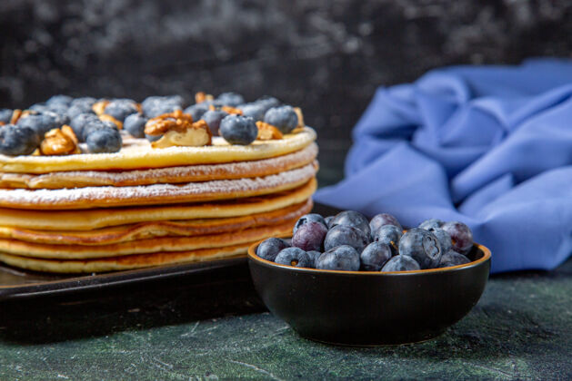 视野前视图美味的蜂蜜蛋糕与蓝莓和核桃内板黑暗的表面浆果水平水果