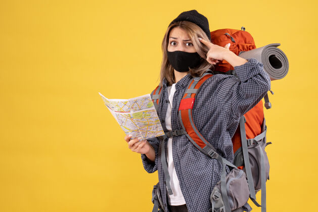 设备困惑的旅行女孩与黑色面具和背包持有地图前视图微笑氧气面罩地图