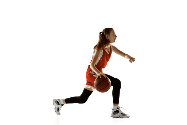 持球年轻的白人女子篮球运动员在行动 运动在运行孤立的白色背景红发运动女孩运动的概念 运动 活力和动态 健康的生活方式训练比赛场地扣篮