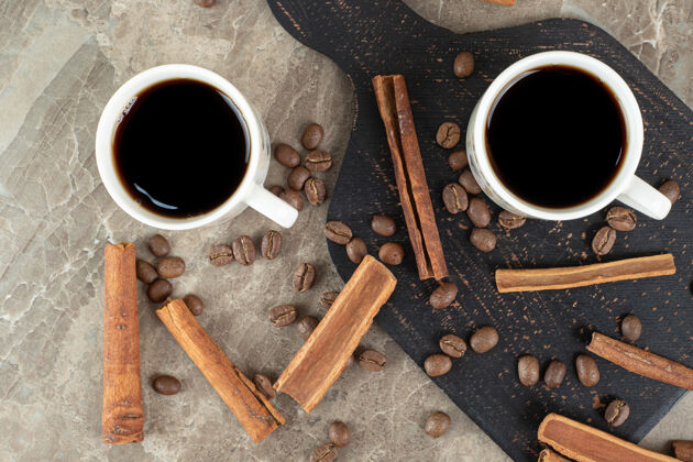热浓缩咖啡 肉桂棒和咖啡豆在大理石表面棒香味