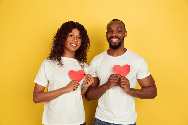 庆祝捧着红色的心情人节庆典 黄色工作室背景上的一对快乐的非洲裔美国夫妇人类情感的概念 面部表情 爱情 关系 浪漫的节日关系面部举行