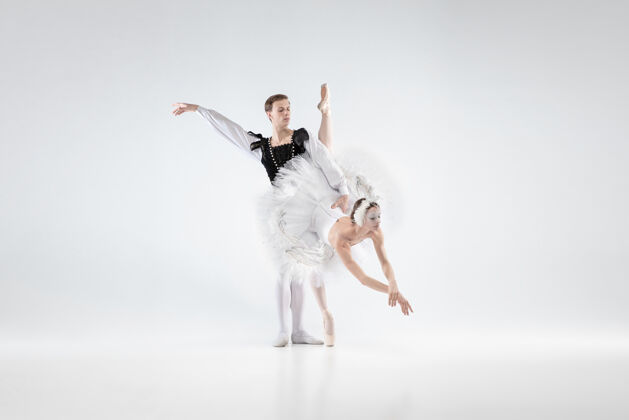 温柔支持优雅的经典芭蕾舞演员在白色工作室背景上孤立地跳舞穿着柔软衣服的情侣像一只白天鹅优雅 艺术家 动作 动作概念现代人舞蹈