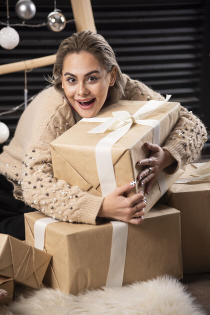 坐着漂亮女人拥抱一盒圣诞礼物的画像成人美女可爱