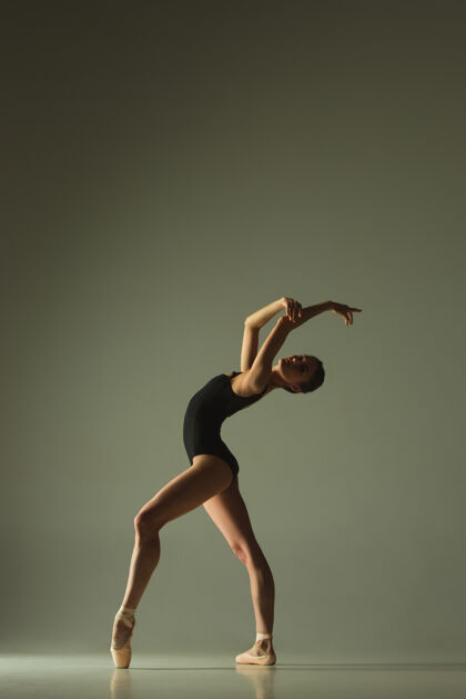女孩优雅的芭蕾舞演员或经典的芭蕾舞演员 在灰色的工作室背景下跳舞表现出灵活性和优雅舞蹈 艺术家 当代 运动 动作和运动概念舞蹈姿势移动